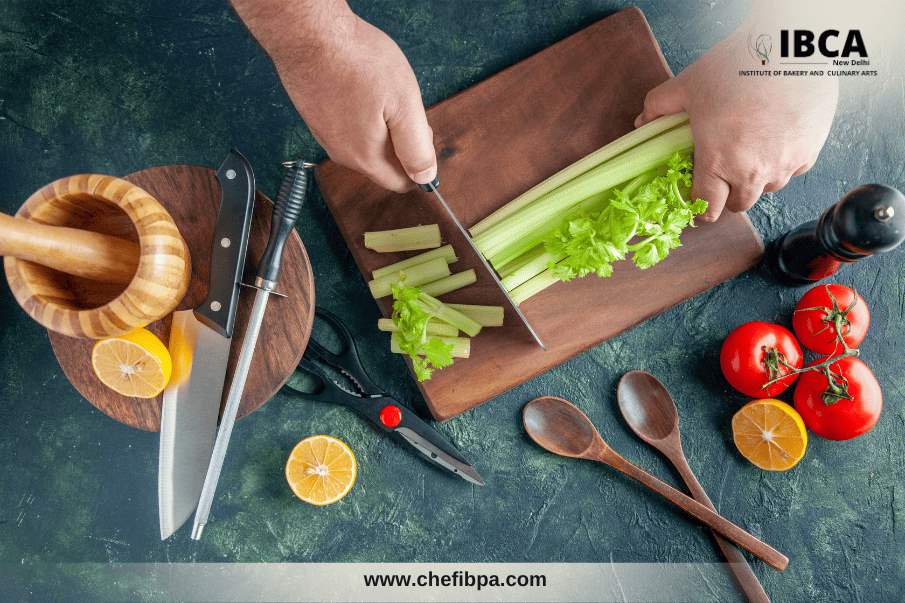 chef chopping celery stalks on a wooden cutting board
