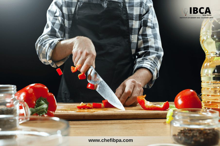 chef chopping red bell peppers on a cutting board